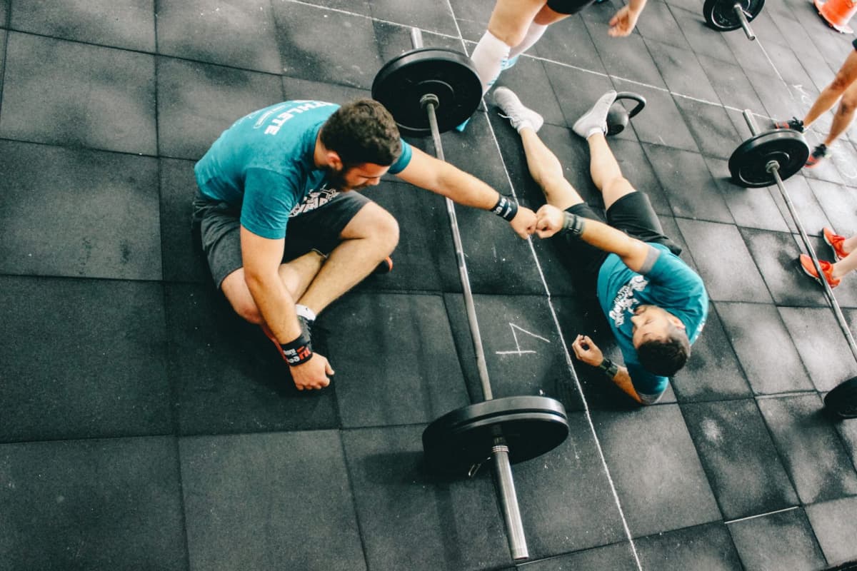 Two men fist bumping while weight training