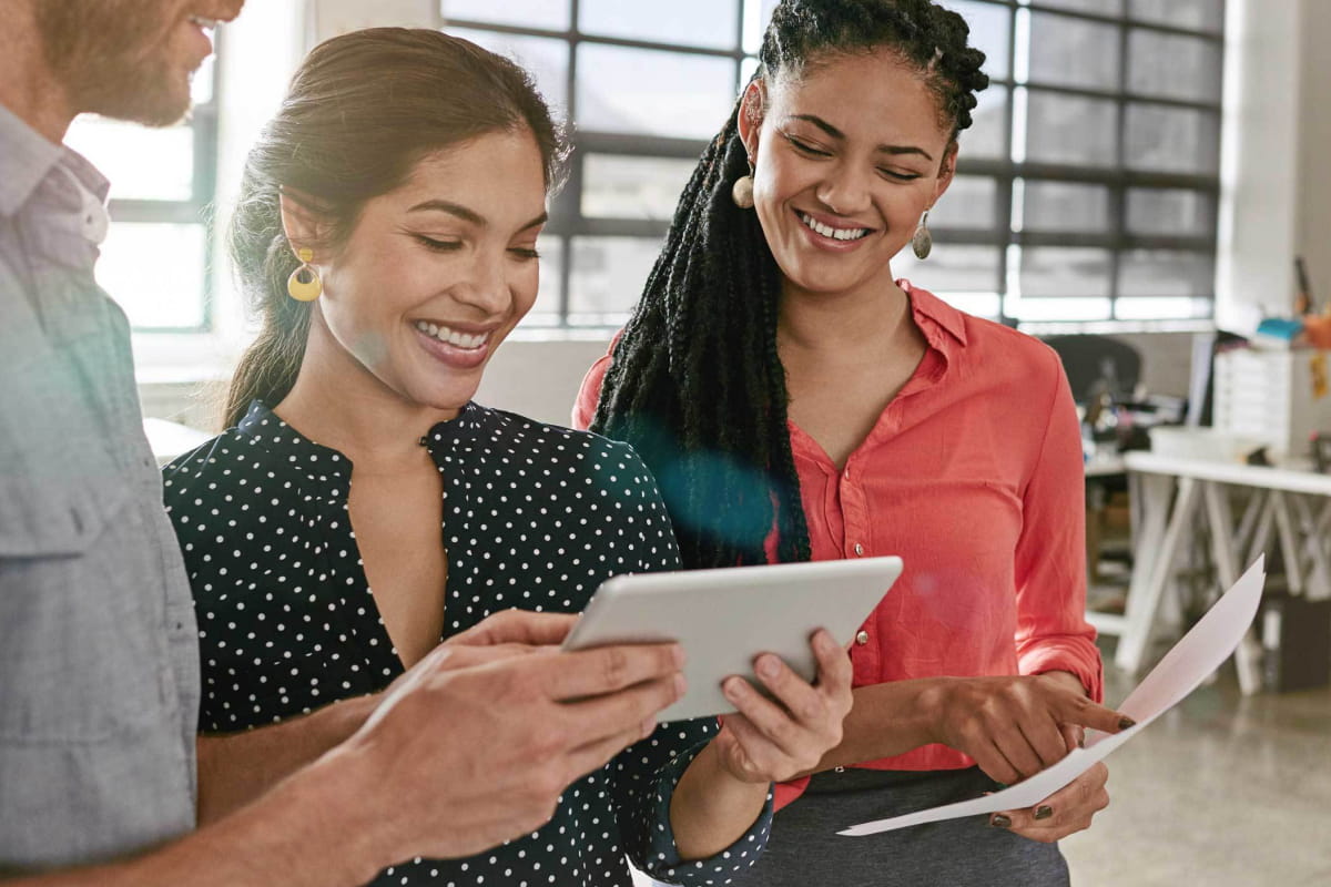 diverse coworkers using tablet for brainstorming session in modern office