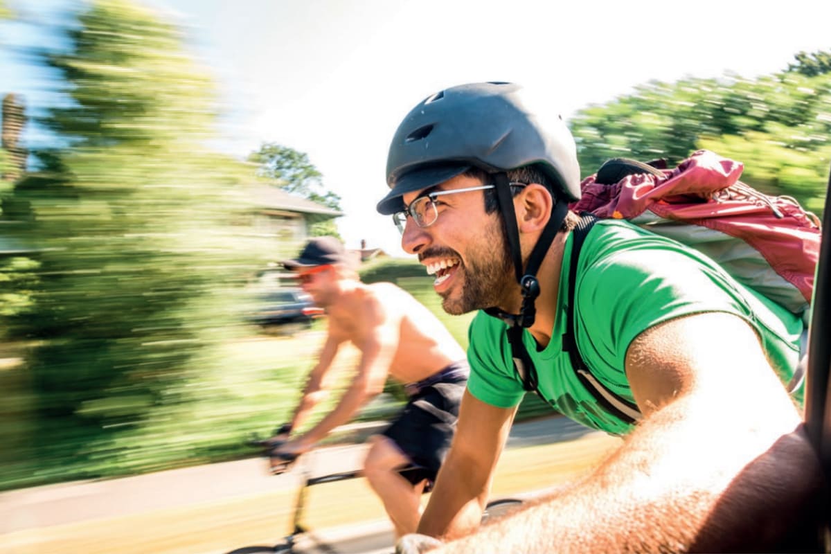 Two men riding on a bike smiling