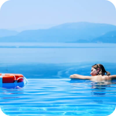 Woman in blue swimming pool with red lifesaver nearby