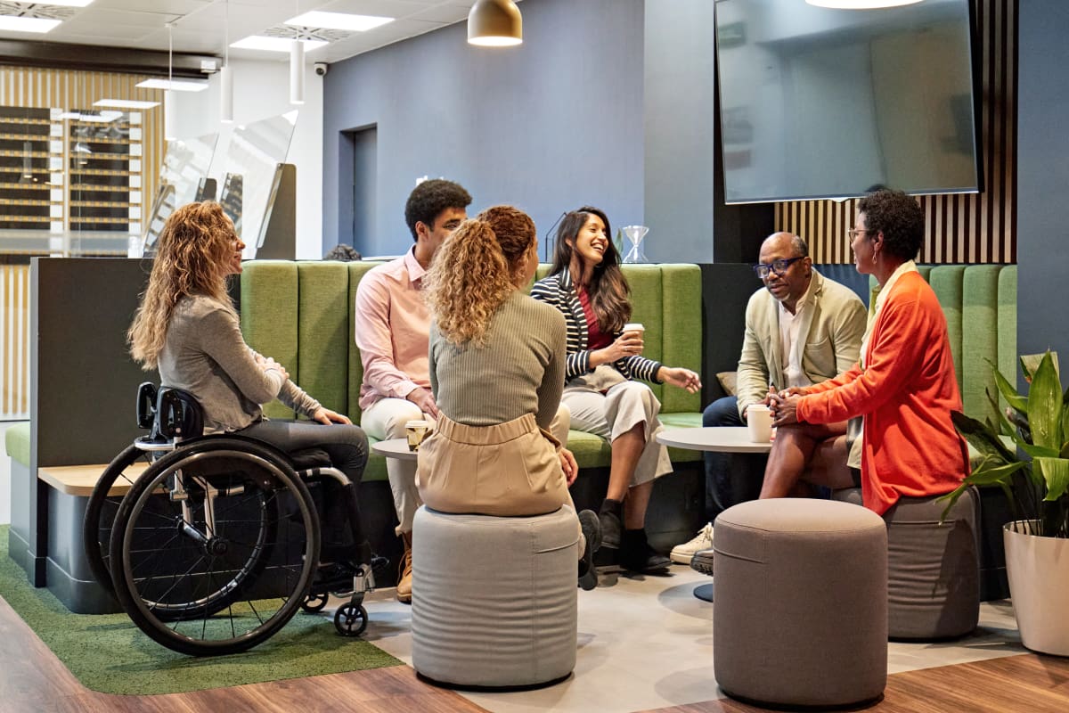 diverse colleagues in business team meeting in modern office sitting area